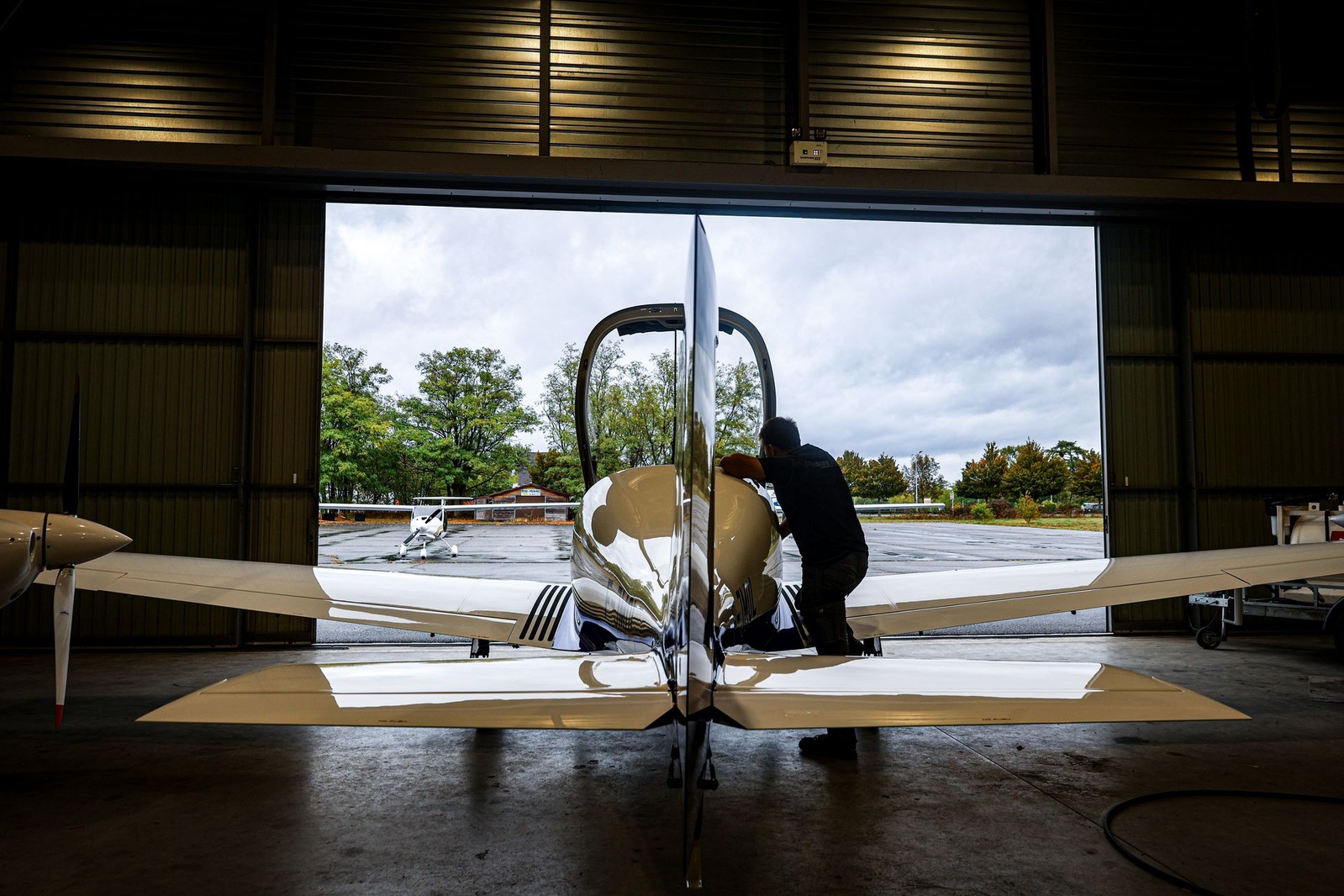 Le Dynamic WT9 F-JMOL dans le hangar Finesse Max, portes ouvertes sur le parking